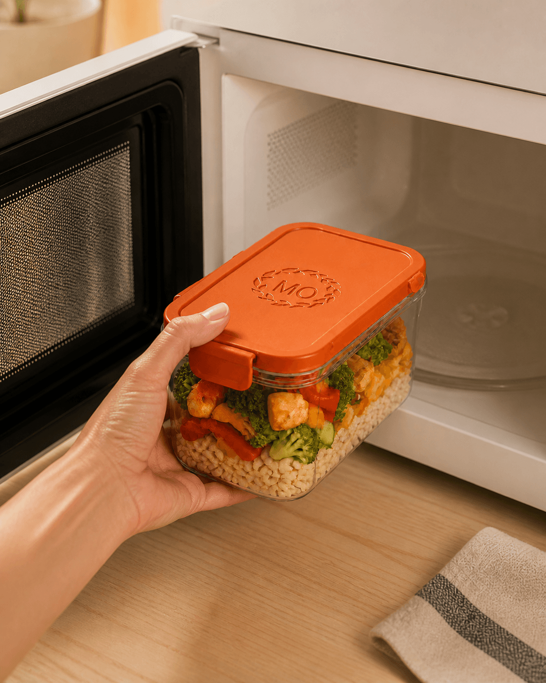 A Monday Serotiny meal container being placed into a microwave
